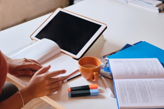 close-up-photo-girl-studying-with-tablettextbooks-cup-coffee-desk-cozy-home (1)