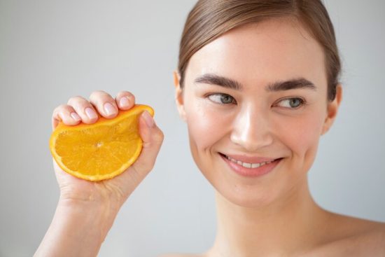 portrait-beautiful-woman-with-clear-skin-holding-sliced-orange-fruit_23-2149207899