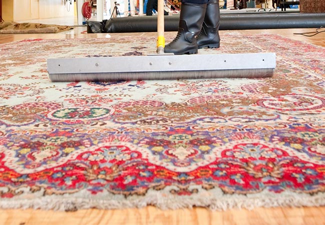 professional-man-rug-cleaning-with-broom-brush